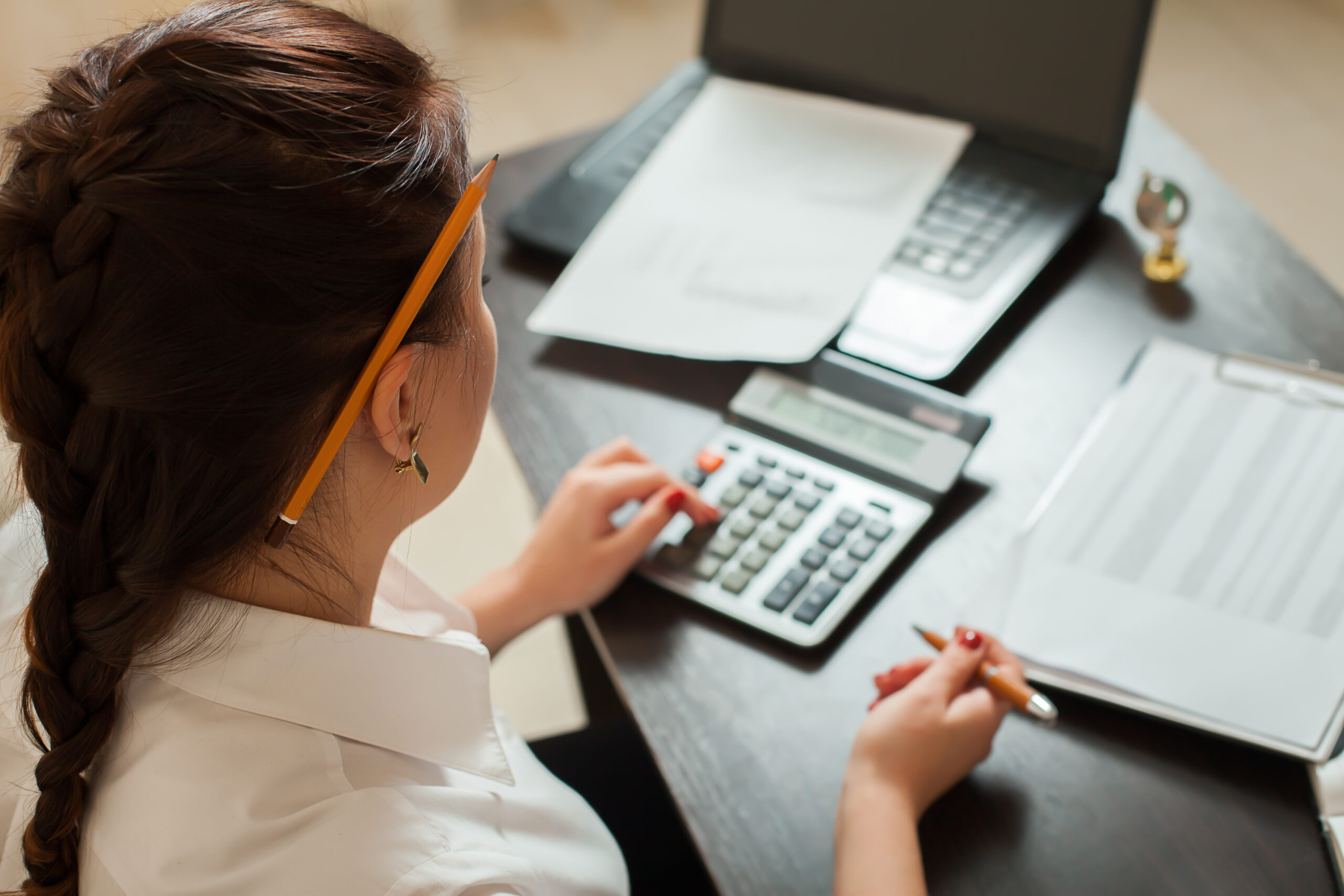 female accountant at desk with calculator