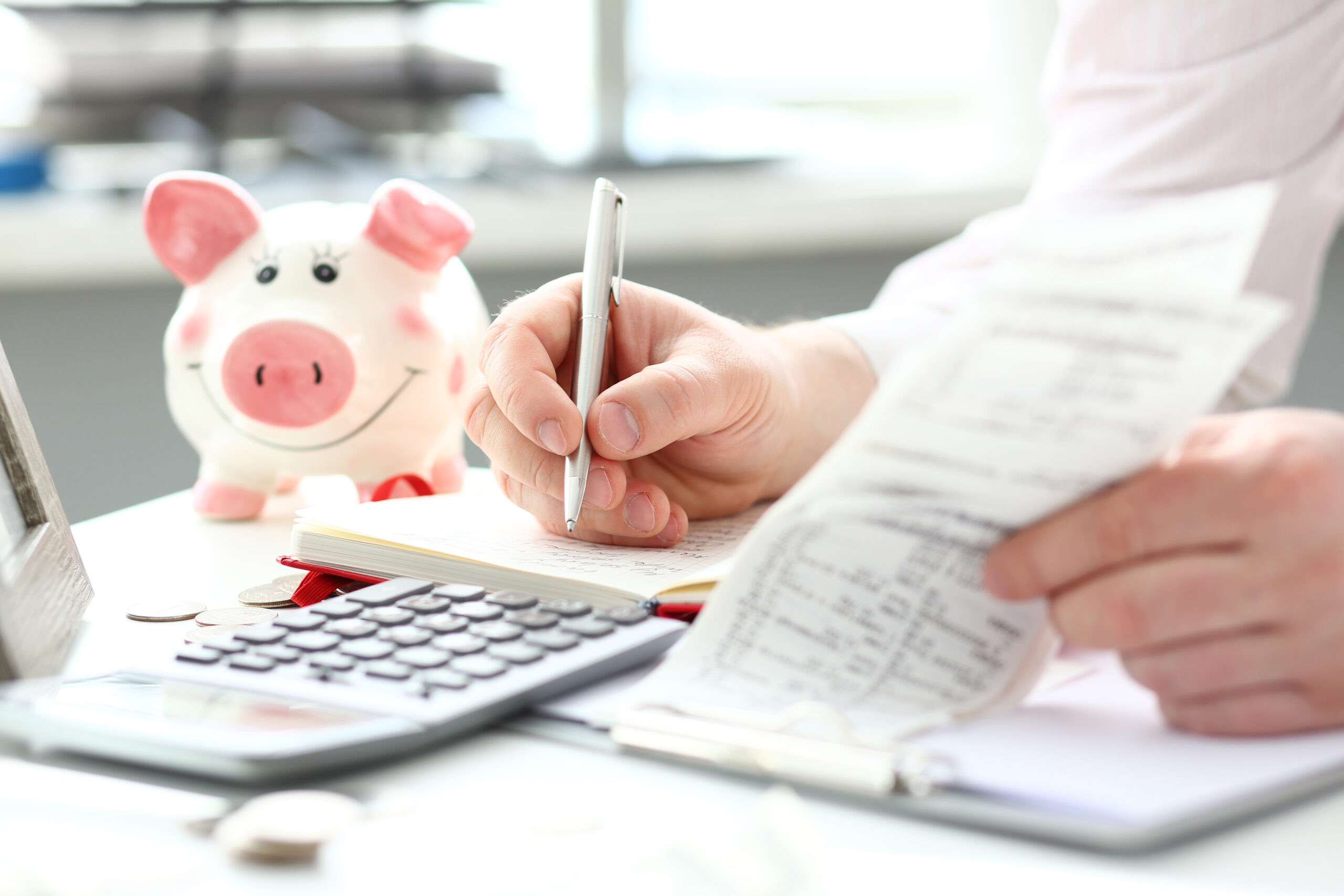 accountant working at their desk with piggy bank in foreground