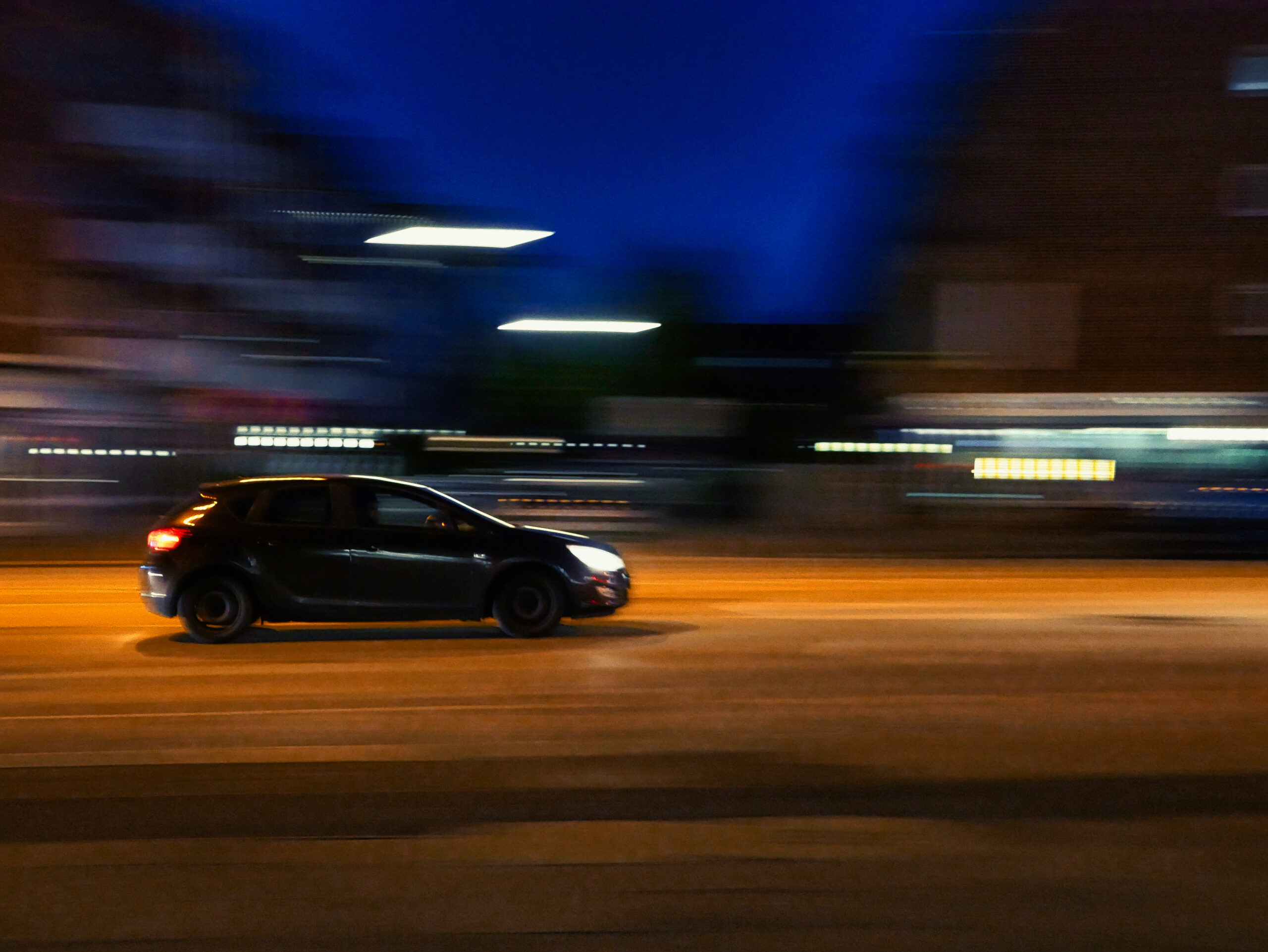 car driving down city street at night