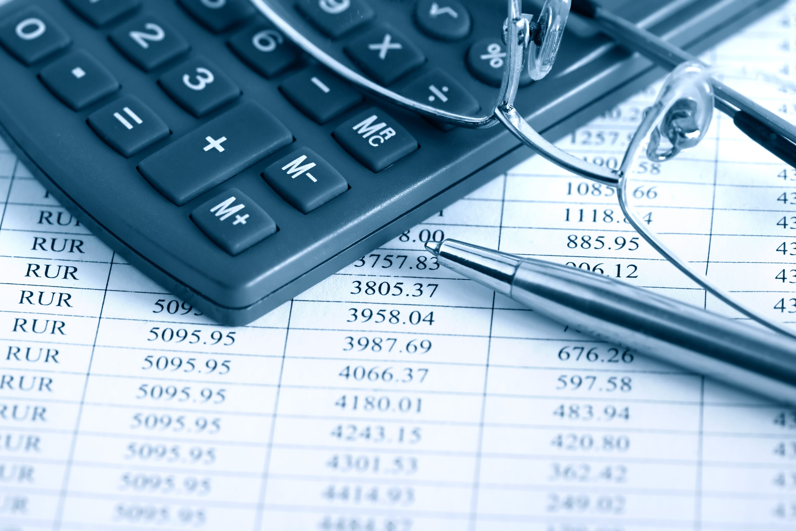 calculator, glasses, and pen over documents
